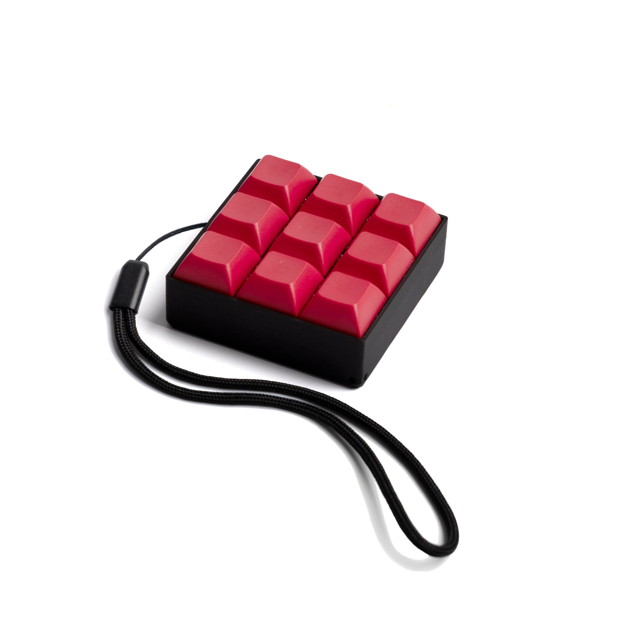 A red and black 9 key mechanical keyboard keychain with a clicky sound, attached to a black strap.
